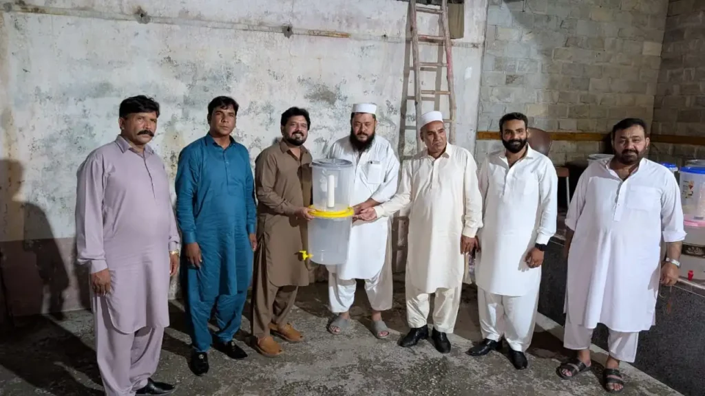 Volunteers distributing clean drinking water to poor families through ACC mission